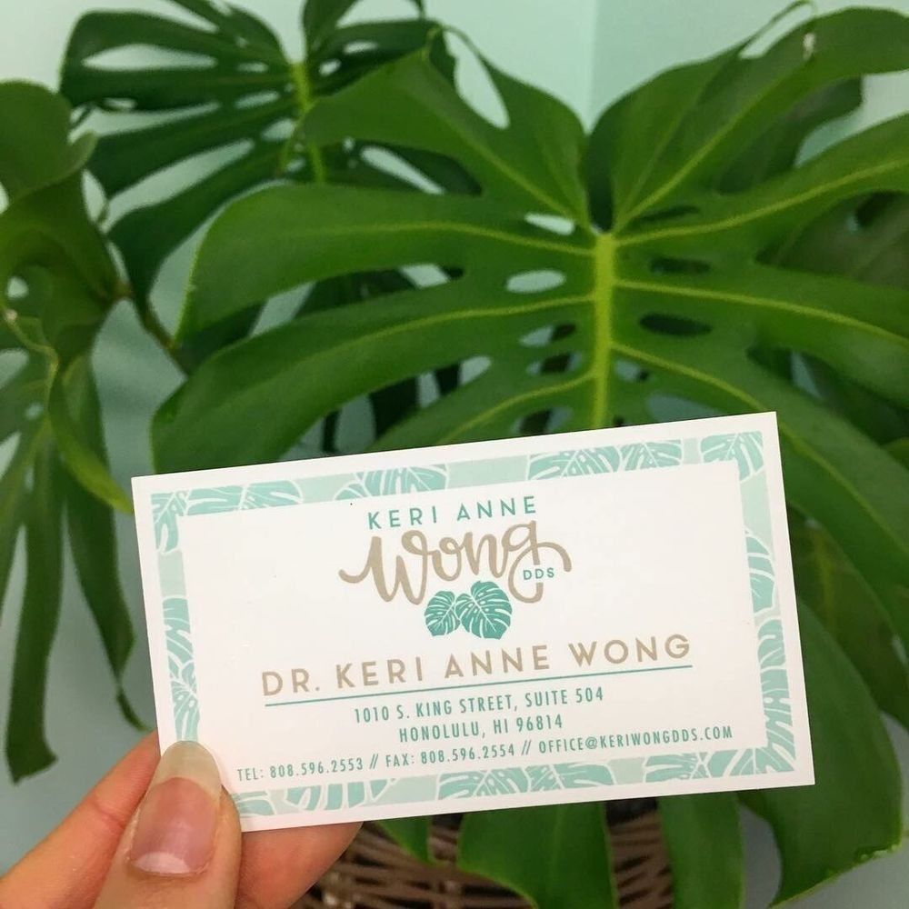 Dr. Keri Anne J. Wong, DDS business card showing the practice's monstera-leaf branding and Honolulu address